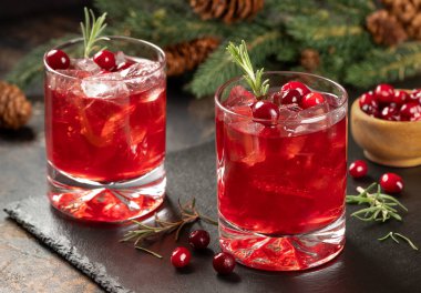 Yaban mersini kokteyli, taze kızılcık ve siyah tahtada biberiye. Arka planda fidan dalı ve çam kozalakları