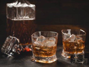 Kopya alanı için iki bardak buzlu viski ve ahşap arka planda sürahi.
