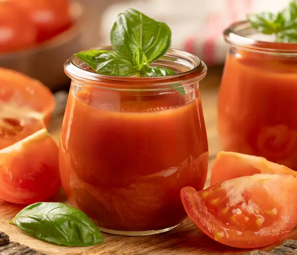 两杯番茄汁加罗勒叶 把西红柿片放在木盘上 图库图片
