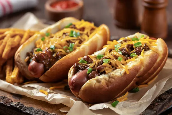Két Chilis Hot Dogot Aprított Cheddar Sajttal Apróra Vágott Zöldhagymával Jogdíjmentes Stock Fotók