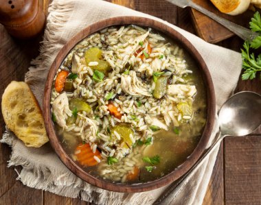 Tahta bir masada havuç ve kereviz ile bir kase tavuk ve pirinç çorbası. Genel Görünüm