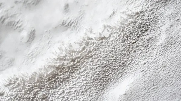 stock image A close-up of a textured, white surface with intricate, snowy peaks and valleys, resembling a delicate winter landscape.