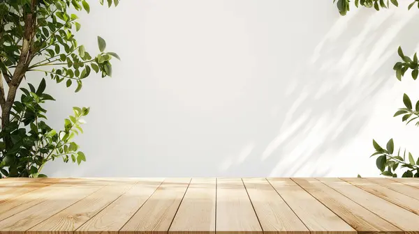 stock image Wooden table with green leaves casting shadows, creating a natural and serene setting.