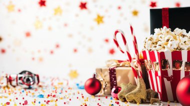 A festive New Year's party table decorated with champagne glasses, confetti, party hats, and a clock showing midnight, set against a white background. clipart