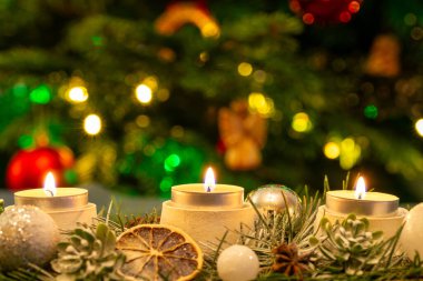 Noel ağacının önünde yanan üç mum. Sığ alan derinliği, kopyalama alanı.