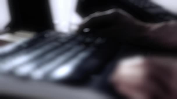 Pcのキーボードの下でゆっくりタイプする男性の手は シーンは重い欠陥レンズボケによって抽象化されます — ストック動画