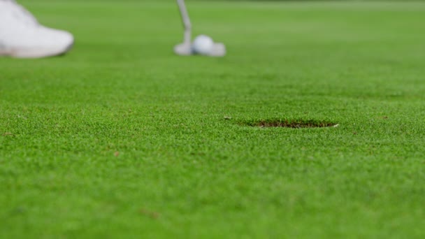 ゴルファーはゴルフボールを打ちますが 穴を見逃します 慎重に維持された緑の上のゴルファーの地上レベルでクローズショット ゴルファーはゴルフボールを置きますが 穴を見逃します — ストック動画