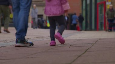 Bokeh 'te yayalar ve müşterilerle dolu şehir merkezi caddesi. İngiltere 'de şehir dolandırıcılığının ve ticari perakende faaliyetlerinin spesifik olmayan temsili. Şehir koşuşturması ve ticari faaliyet için spesifik olmayan temsiller gerektiren projeler için ideal.