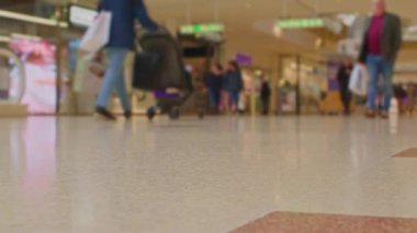Bokeh 'te alışveriş merkezinin önünden geçen müşteriler var. İngiltere 'de şehir dolandırıcılığının ve perakende faaliyetlerinin spesifik olmayan temsili.