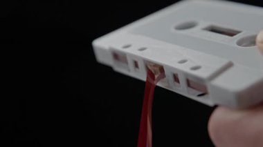 Rüzgâr Gevşetici Manyetik Kaydı Ses Kasetine Çekmek için Tükenmez Kalem Kullanıyor. Tükenmez kalem eski bir beyaz ses kasetinin merkezine yerleştirilir, kalem gevşek bir ses bandına çevrilir ve kasete geri konur.. 