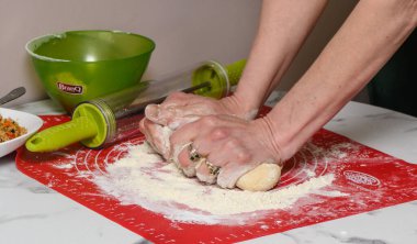 Kadın, Çin usulü şeffaf börek yapıyor.