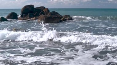 Kıbrıs adasındaki Akdeniz 'in dalgalarında sahile yakın denizde taşlar var.