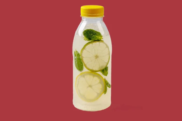 Mojito lemonade with lemon, lime, mint, mojito syrup, ice, sparkling water on red background for food delivery website 1