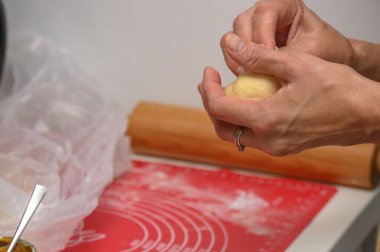 Kadın mutfakta çörek yapıyor.