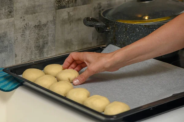woman placing buns on a baking sheet 7