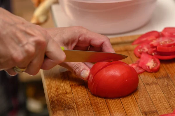 woman cutting tomato on kitchen board 4