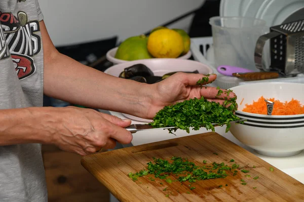 woman cutting parsley on a cutting board in the kitchen 6