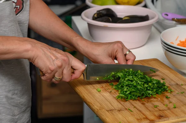 woman cutting parsley on a cutting board in the kitchen 3