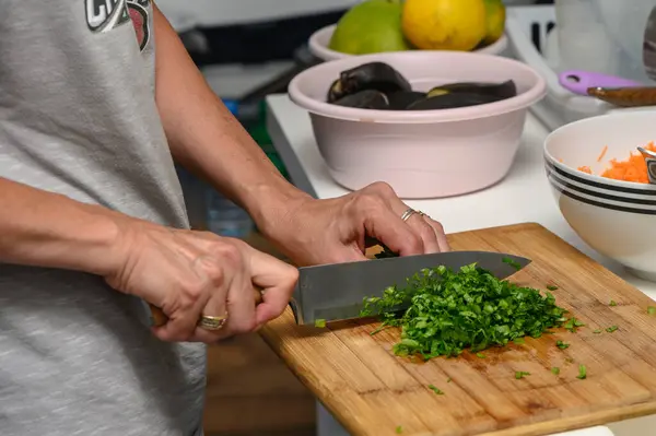 woman cutting parsley on a cutting board in the kitchen 2