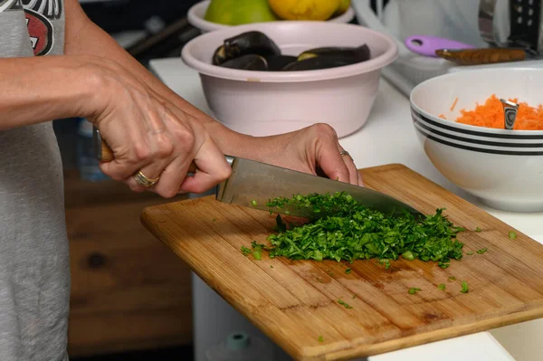 woman cutting parsley on a cutting board in the kitchen 5