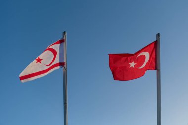 Kuzey Kıbrıs Türk Cumhuriyeti ve Türkiye 'nin bayrakları mavi gökyüzüne karşı