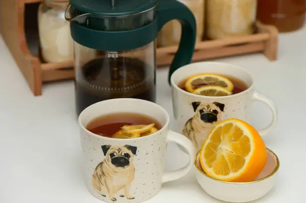 black tea with lemon in cups with a drawn pug 2