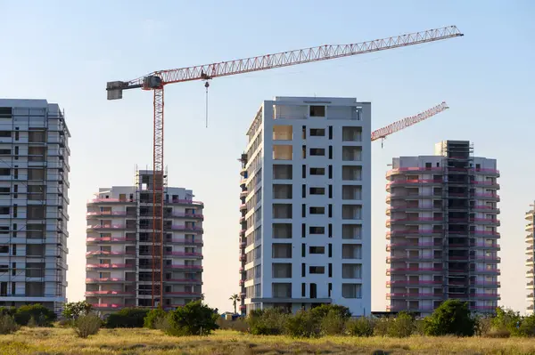 İnşaat alanlarının panoramik manzarası ve yeni bir inşaat işinde çalışan pek çok vinç.