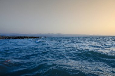 Akdeniz 'in ılık dalgaları ve gün doğumunda kumlu bir sahil.