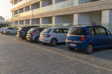 Gaziveren Kıbrıs 06.29.2024 otomobille gün batımında bir yerleşim alanındaki bir otoparkta