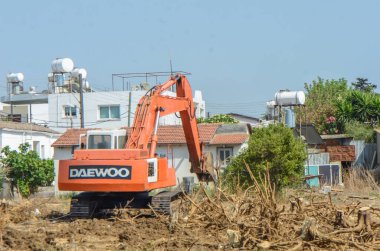 Gazeveren Kıbrıs 03.07.2024 - kazıcı portakal ağaçlarının kökünü kazıyor