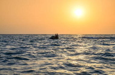 Siluet sporcusu jet ski ve su spreyine biniyor.