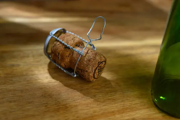 stock image One champagne cork and a ray of light, on a wooden table on a white background