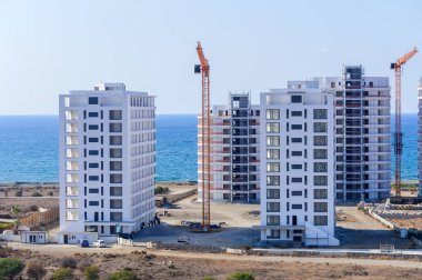 Işıldayan denizin ortasında, kıyı gelişiminde yükselen binalar, berrak bir gökyüzüne ve manzaralı bir zemine karşı modern mimariyi gözler önüne seriyor..