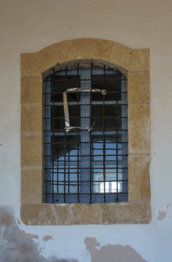 The old stone window frame features iron bars, highlighting a blend of architecture and nature light. clipart