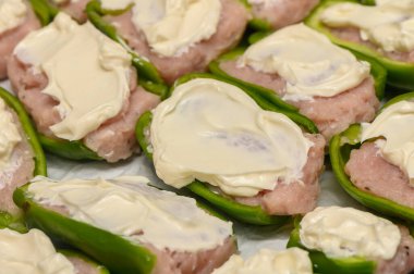 Platter of green bell peppers generously filled with a rich and creamy mixture, evoking comfort food vibes. clipart