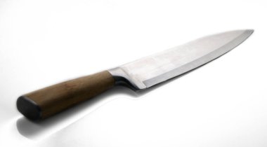 Glinting blade of a kitchen knife lies on a clean surface, inviting creativity for meals and culinary adventures. clipart