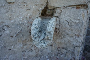 A unique stone carving stands out on a weathered wall, showcasing intricate details and historical significance. clipart