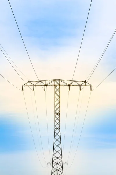 蓝天背景黄光高压电塔电缆线路 — 图库照片