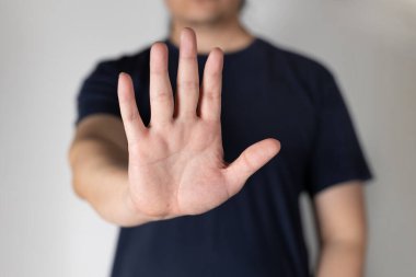 Asyalı adam dur işareti olarak el hareketlerini gösteriyor..
