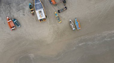 Denizin suları çekildiği sırada kumdaki boş balıkçı teknelerinin hava görüntüsü. Yukarıdan İHA atışı. 