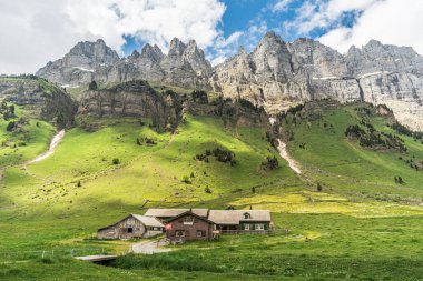 İsviçre 'nin en büyük alp' i olan Urnerboden 'daki dağlık barakalar ve ambarlar Klausenpass yakınlarındaki Glarus Alpleri' nin eteklerinde