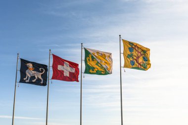 Rüzgarda dalgalanan bayraklar mavi gökyüzü arka planında (soldan sağa doğru: Ermatingen belediye bayrağı, İsviçre bayrağı, Thurgau Kantonu, Triboltingen belediye bayrağı), Ermatingen, Thurgau Kantonu, İsviçre