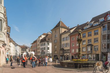 Schaffhausen, Schaffhausen Kantonu, İsviçre - 30 Mart 2025. Fronwagplatz, sağ tarafında Landsknecht çeşmesi olan canlı bir meydan, eski Schaffhausen kasabasının yaya bölgesinde yer alıyor.