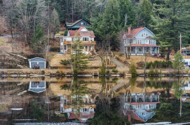 Saranac Gölü, New York, ABD - 10 Nisan 2013. Saranac Gölü 'ndeki göl kenarındaki evler, Adirondack Dağları