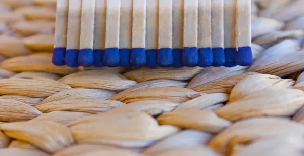 stock image Wooden matches on a straw background. Close-up shot.