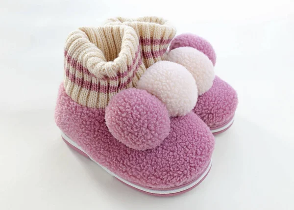 Woolen house children\'s slippers with balabon. Pink warm slippers for girls. A pair of child\'s shoes for cold weather on a white background.