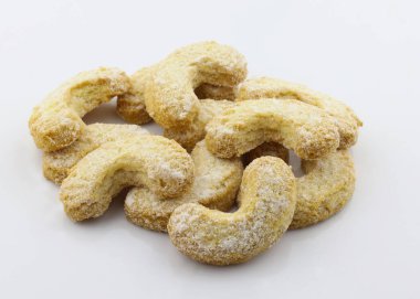 Yarım ay şeklindeki kurabiyeler üzerine pudra şekeri serpiştirilmiş. Beyaz arka planda yakın plan kurabiyeler. Ev Yapımı Tatlı Kurabiyeler Yemeye Hazır