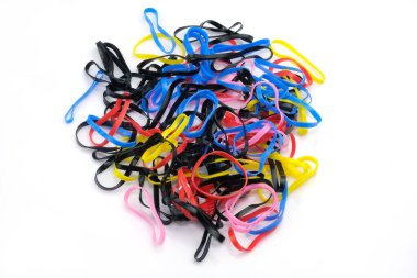 Kauçuk bantlar beyaz arka planda ince renkli silikon. Bir çift küçük silikon saç teli. Farklı renkte örgüler için elastik bantlar. Afrika örgüleri için çok renkli elastik bantlar