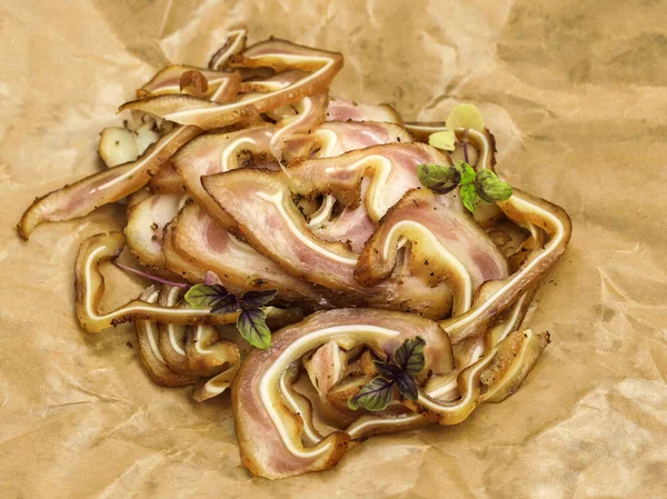 Mikro yeşil bazilikayla süslenmiş soslu kızarmış domuz parçaları. Kağıt üzerinde marine edilmiş domuz kulağı. Biraya atıştırmalık: domuz yağı, füme domuz kulağı.