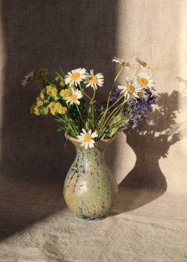 Bir buket yabani çiçekli modern el işi vazo. Üzerinde yeşil jöle olan seramik vazo. Eşsiz el yapımı kil vazo. Clay dekoratif unsurları. Alışılmadık vazo.